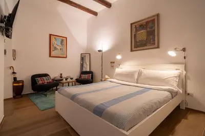 a bedroom with a large bed and two chairs at The Luxury Roma Amor in Rome
