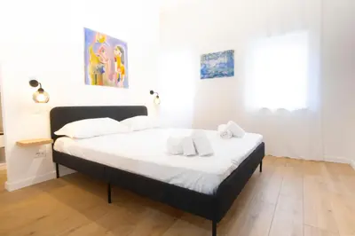 a bedroom with a bed with white sheets and white pillows at Elegantis Santa Croce Suite Apartment in Rome