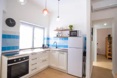 a kitchen with a white refrigerator and a window at Elegantis Santa Croce Suite Apartment in Rome