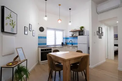 a kitchen with a wooden table and chairs in a room at Elegantis Santa Croce Suite Apartment in Rome