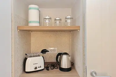 a kitchen shelf with a toaster and cups on it at Balconcino romantico a via Aosta in Rome