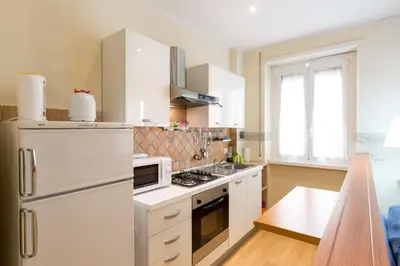 a kitchen with a white refrigerator and a stove top oven at Casa Vacanze La Bomboniera in Rome