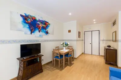 a living room with a tv and a dining room table at Casa Vacanze La Bomboniera in Rome