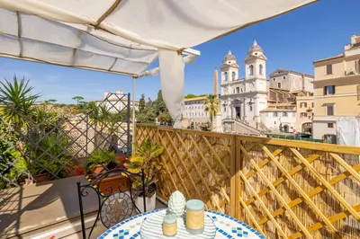 a balcony with a table and chairs and a building at Suite Spagna - Terrazza su Piazza di Spagna in Rome