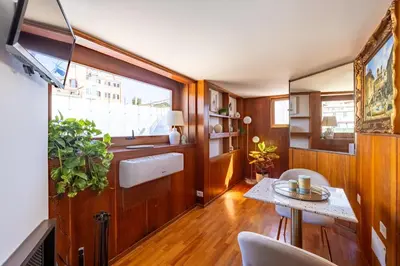 a living room with a table and a window at Suite Spagna - Terrazza su Piazza di Spagna in Rome