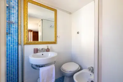 a bathroom with a sink and a toilet and a mirror at Suite Spagna - Terrazza su Piazza di Spagna in Rome