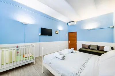 a blue room with a bed and a couch at Children House Apartment in Rome