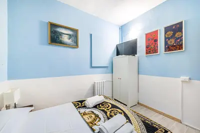 a blue room with a bed and a refrigerator at Children House Apartment in Rome