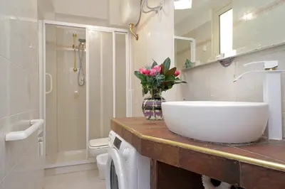 a bathroom with a sink and a vase of flowers on a counter at Olimpia in Rome