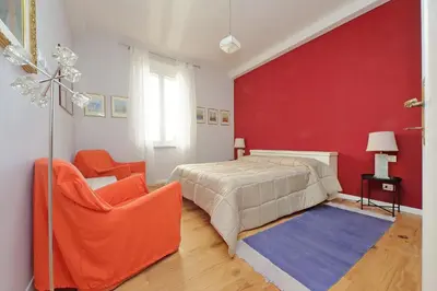 a bedroom with a bed and a red wall at Olimpia in Rome
