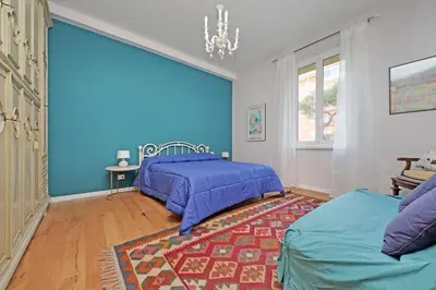 a bedroom with blue walls and a bed and a rug at Olimpia in Rome