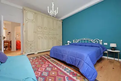 a blue bedroom with a bed and a blue wall at Olimpia in Rome
