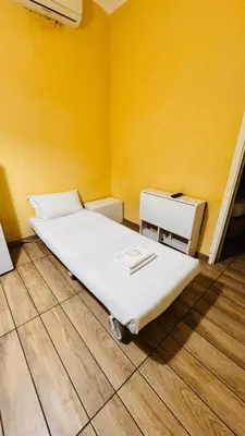 a bed in a room with a yellow wall at Kotel rome residenza piazza bologna in Rome
