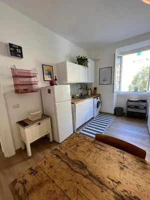 a kitchen with a white refrigerator and a table at La Spezia 28 Royal in Rome