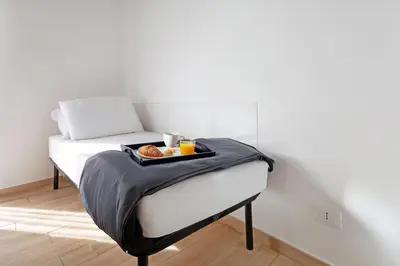 a bed with a tray of donuts and drinks on it at Luciano Colosseo Apartment in Rome