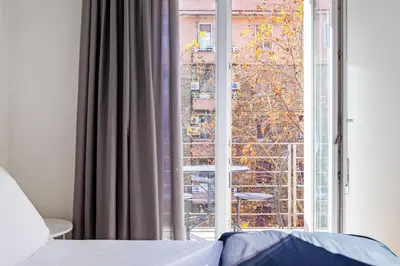 a bedroom with a bed and a large window at Luciano Colosseo Apartment in Rome