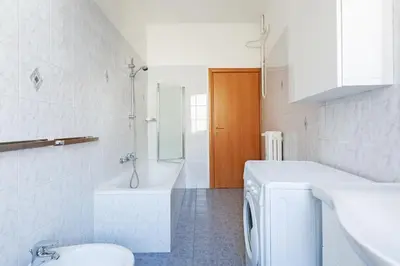a white bathroom with a toilet and a sink at Luciano Colosseo Apartment in Rome