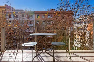 a table and two chairs sitting on a balcony at Luciano Colosseo Apartment in Rome