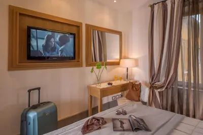 a bedroom with a bed with a television on the wall at The Inn at the Spanish Steps Prestige Collection - MDR Penthouse in Rome