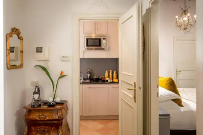 a room with a bed and a kitchen with a microwave at The Inn at the Spanish Steps Prestige Collection - MDR Penthouse in Rome