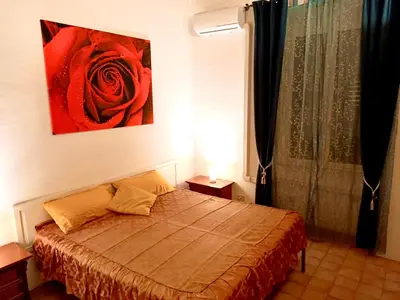 a bedroom with a bed with a red rose on the wall at 2B Domus Vaticana 