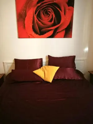 a bed with a painting of a red rose at 2B Domus Vaticana 