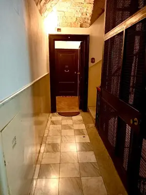 a hallway with a black door and a tiled floor at 2B Domus Vaticana 