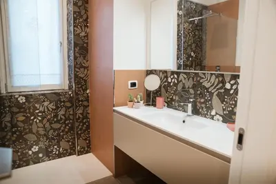 a bathroom with a tub and a sink and a mirror at A Casa di Emy in Rome
