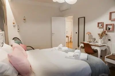 a bedroom with a large white bed and a table at A Casa di Emy in Rome