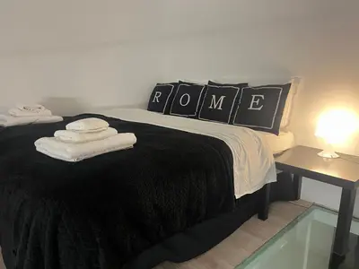a bedroom with a black bed with towels on it at Modern Loft in the center of Rome in Rome