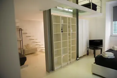 a room with a glass partition with a bed and a television at Modern Loft in the center of Rome in Rome