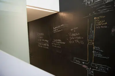 a blackboard with white writing on a wall at Modern Loft in the center of Rome in Rome