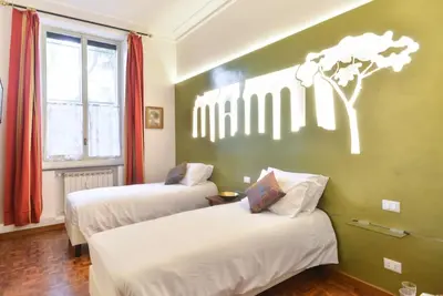 a room with two beds and a wall with a giraffe on it at A Star Inn in Rome
