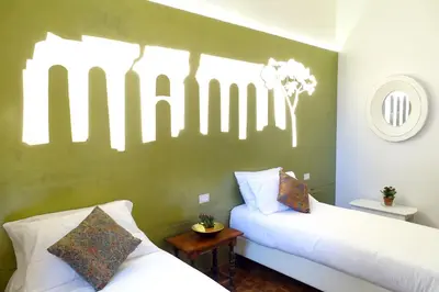 two beds in a room with a green wall at A Star Inn in Rome