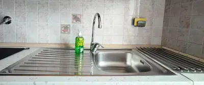 a sink in a kitchen with a green bottle on it at CasAppia in Rome