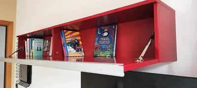 a red book shelf with books on it at CasAppia in Rome