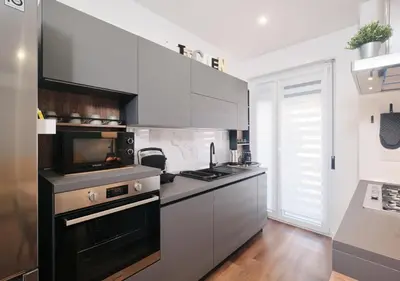 a kitchen with a black and white stove top oven at COLOSSEO a 15 minuti - Suite Elegante in Centro in Rome