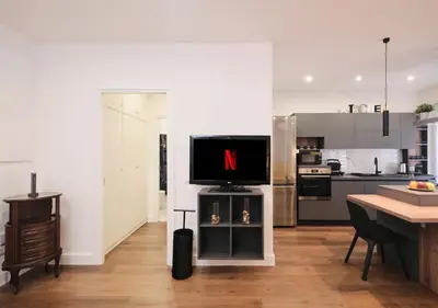 a kitchen with a tv on a stand with a table at COLOSSEO a 15 minuti - Suite Elegante in Centro in Rome