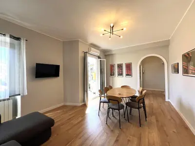 a living room with a table and a couch at L'affaccio sul borgo - Adiacente Metro B in Rome
