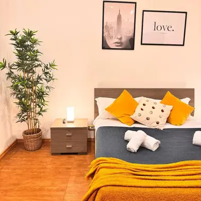 a bedroom with a bed with yellow and white pillows at Charming Home in Termini in Rome