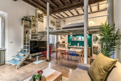 a loft apartment with a spiral staircase and a dining room at Monti View Apartment in Rome