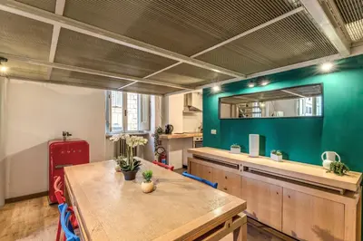 a kitchen with a table and a green wall at Monti View Apartment in Rome