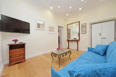 a living room with a blue couch and a table at 4BNB - Ripetta Central Apartment in Rome