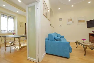 a living room with a blue couch and a table at 4BNB - Ripetta Central Apartment in Rome