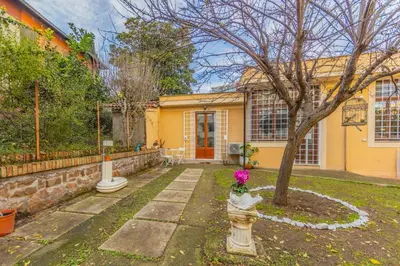a yellow house with a tree in the yard at Villa Gatta in Rome