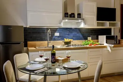 a kitchen with a table with two glasses of wine at Vatican Aurelia House - Vicino alla metro e al Vaticano - Luminoso e moderno in Rome