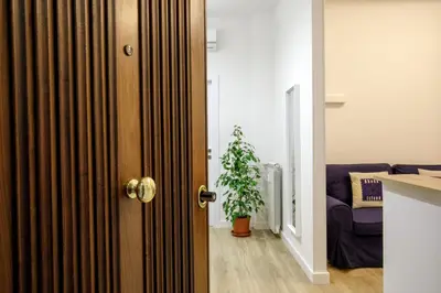 a door leading to a living room with a plant at Vatican Aurelia House - Vicino alla metro e al Vaticano - Luminoso e moderno in Rome