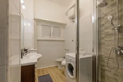 a bathroom with a sink and a washing machine at Vatican Aurelia House - Vicino alla metro e al Vaticano - Luminoso e moderno in Rome