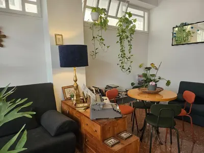 a table with chairs and a vase with flowers on it at That's Theatre House, near the Colosseum! in Rome