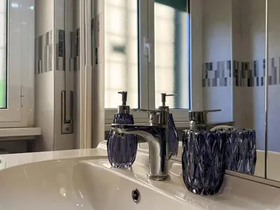 a bathroom sink with a faucet and two glasses on it at JHHIT Tuscolana Suite 01 with Terrace in Rome